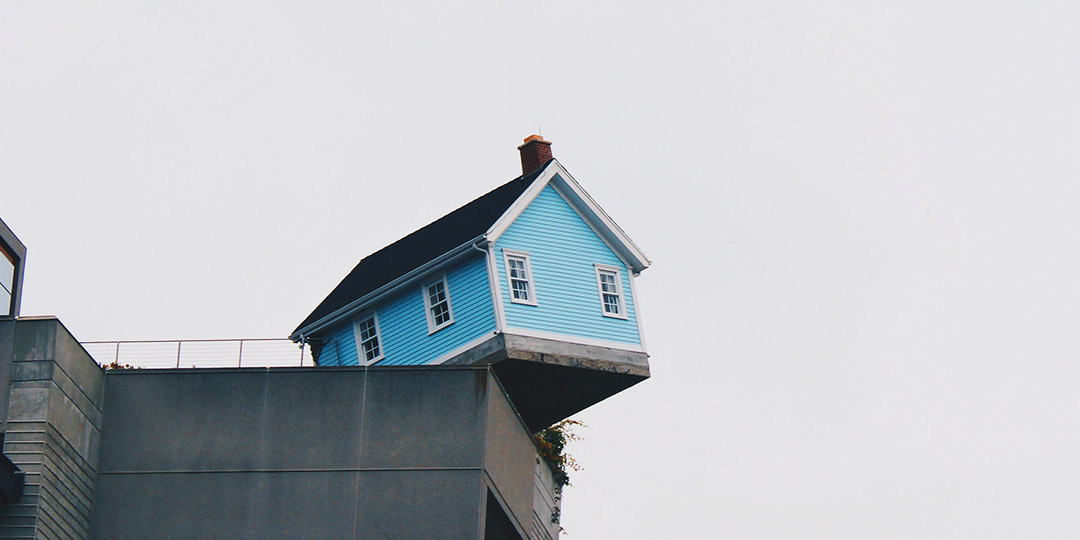 blue house on the edge of a cliff